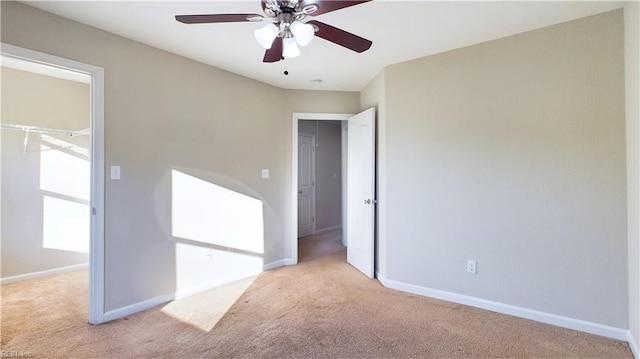 carpeted spare room with ceiling fan