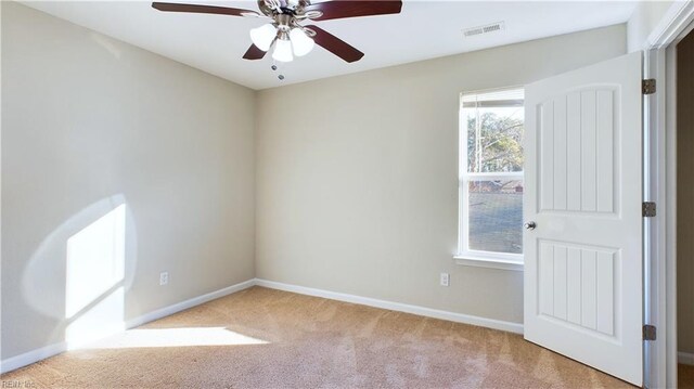 carpeted spare room with ceiling fan