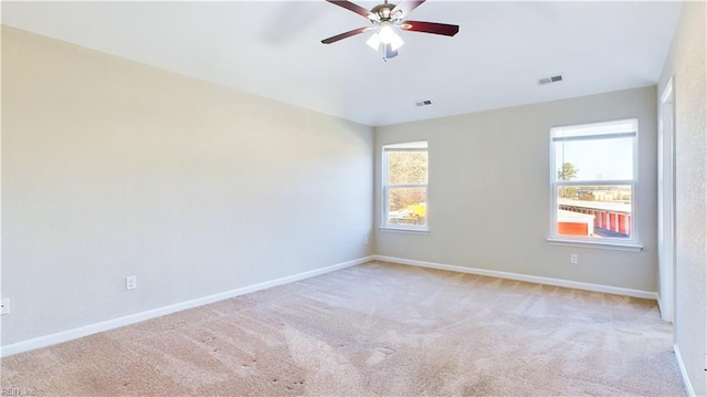 unfurnished room featuring light carpet, ceiling fan, and a healthy amount of sunlight