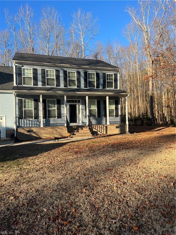 colonial inspired home featuring a porch and a garage