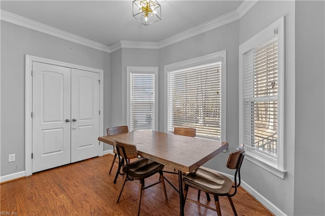 dining space with ornamental molding and wood-type flooring