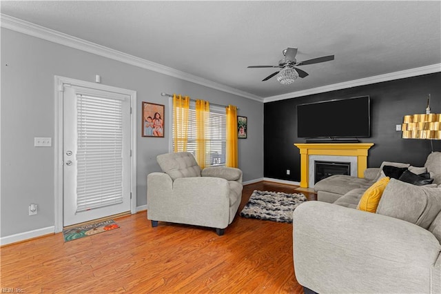 living room with ceiling fan, wood-type flooring, and crown molding