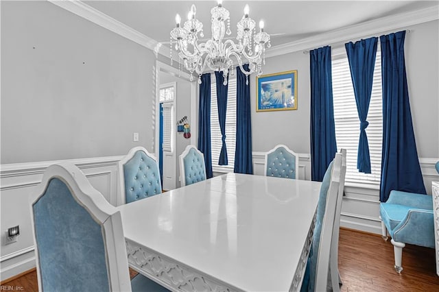 dining space with a chandelier, ornamental molding, and dark hardwood / wood-style floors