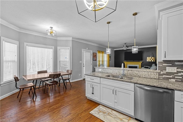 kitchen featuring dishwasher, sink, white cabinets, pendant lighting, and backsplash