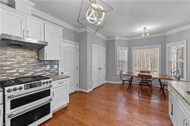 kitchen with light stone countertops, pendant lighting, white cabinets, decorative backsplash, and double oven range