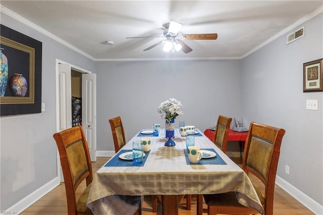 dining area featuring ceiling fan, wood-type flooring, and crown molding