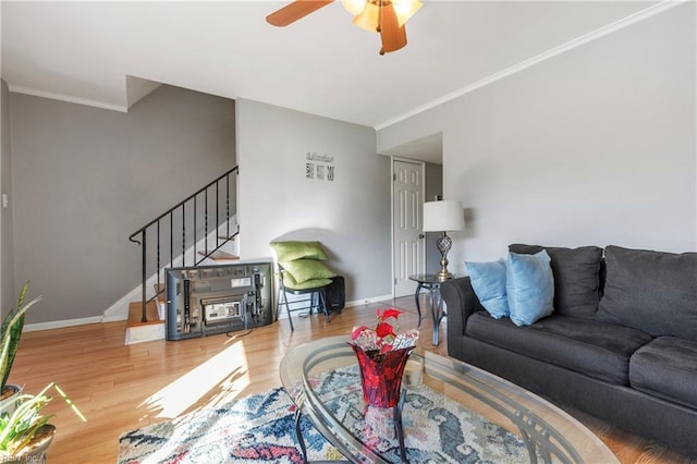 living room with hardwood / wood-style flooring, ornamental molding, and ceiling fan