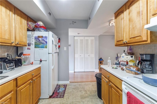 kitchen with decorative backsplash and white appliances