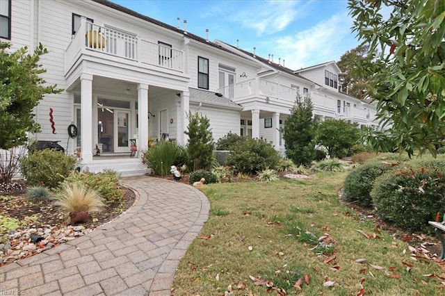 view of front of property with a front lawn and a balcony