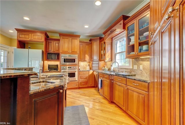 kitchen with tasteful backsplash, sink, stainless steel appliances, and stone counters