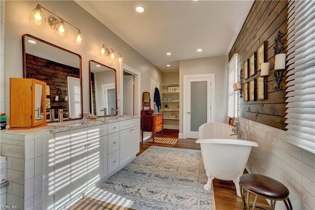 bathroom with a washtub, vanity, and hardwood / wood-style flooring