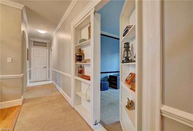 hall with crown molding and light colored carpet