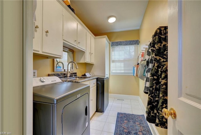 washroom featuring sink, light tile patterned floors, and cabinets