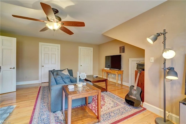 living room with light hardwood / wood-style flooring and ceiling fan