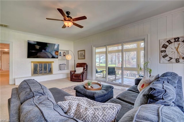 carpeted living room featuring ceiling fan and ornamental molding