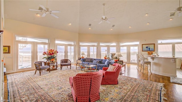 living room with high vaulted ceiling, wood-type flooring, and ceiling fan