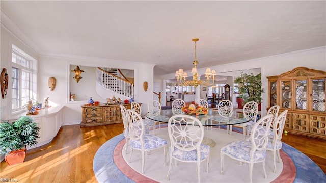 dining area featuring a notable chandelier, crown molding, and hardwood / wood-style floors