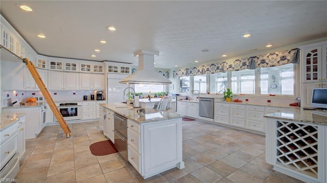 kitchen with white cabinetry, island exhaust hood, a kitchen island with sink, oven, and stainless steel dishwasher