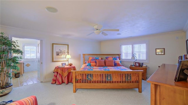 carpeted bedroom with ceiling fan, ornamental molding, and ensuite bath