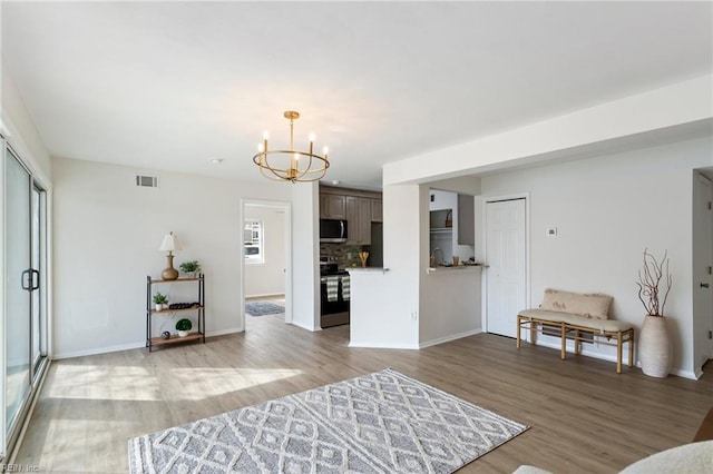 living room with a notable chandelier and light wood-type flooring