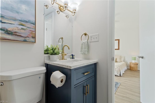 bathroom with vanity, toilet, and wood-type flooring