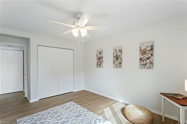 bedroom featuring hardwood / wood-style flooring, ceiling fan, and a closet