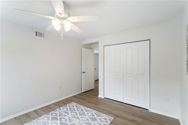 bedroom featuring hardwood / wood-style floors, a closet, and ceiling fan