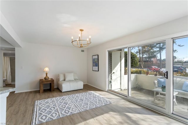 sitting room featuring a notable chandelier and wood-type flooring