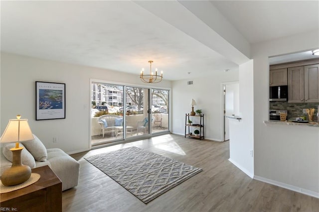 living room with a notable chandelier and light hardwood / wood-style floors