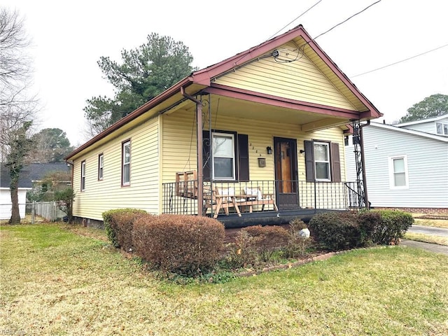 bungalow-style home with covered porch and a front yard