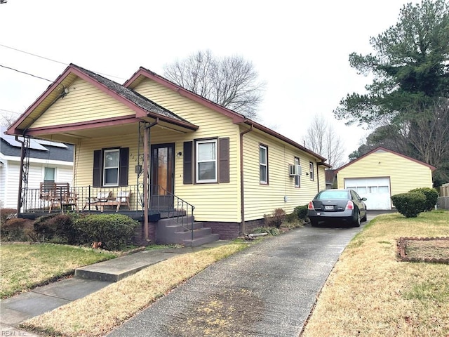 bungalow with a front yard, a porch, an outdoor structure, and a garage