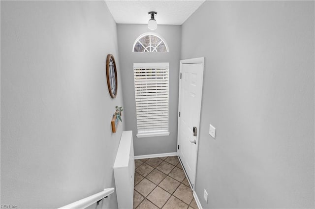 entryway with a textured ceiling and light tile patterned floors