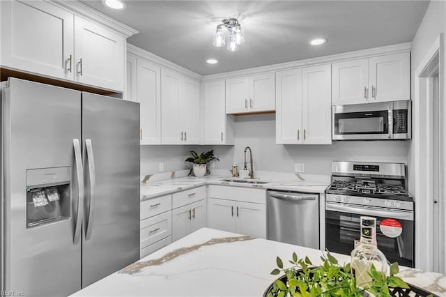 kitchen with light stone counters, sink, white cabinetry, and stainless steel appliances