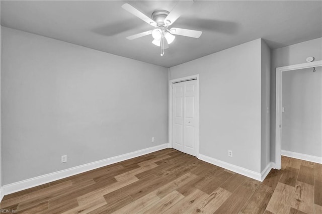 unfurnished bedroom with ceiling fan, a closet, and light wood-type flooring