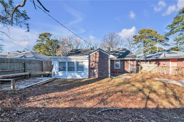 rear view of property featuring cooling unit and a yard