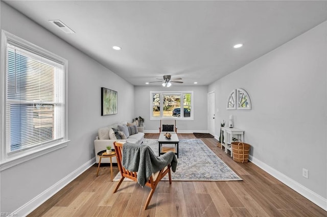 living room featuring ceiling fan and light hardwood / wood-style floors