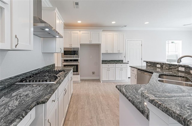 kitchen with sink, dark stone counters, white cabinetry, appliances with stainless steel finishes, and wall chimney exhaust hood