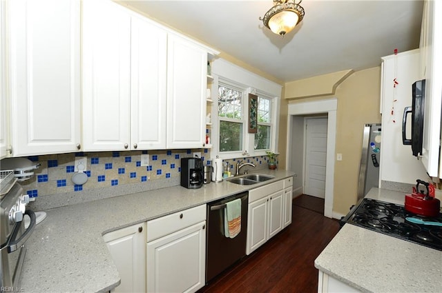 kitchen with backsplash, light stone countertops, black appliances, white cabinets, and sink