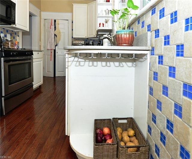 kitchen featuring dark hardwood / wood-style floors, a breakfast bar, sink, stainless steel range, and white cabinets