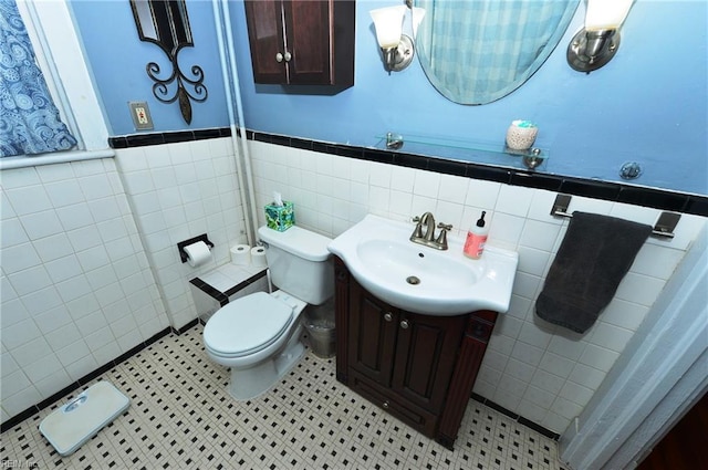 bathroom with tile walls, tile patterned floors, vanity, and toilet