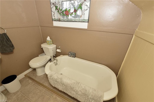 bathroom featuring toilet, a bath, and tile patterned flooring