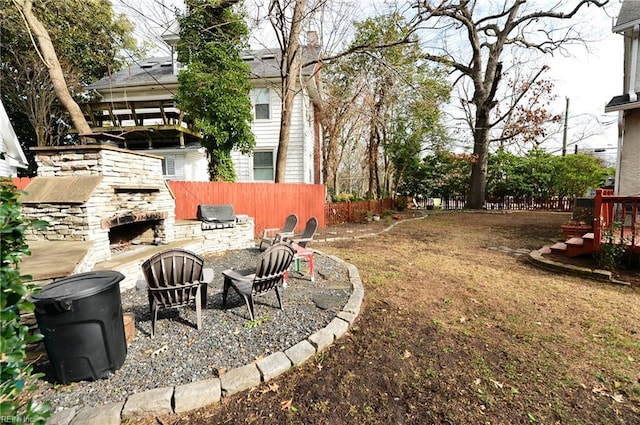 view of yard with an outdoor stone fireplace and exterior kitchen