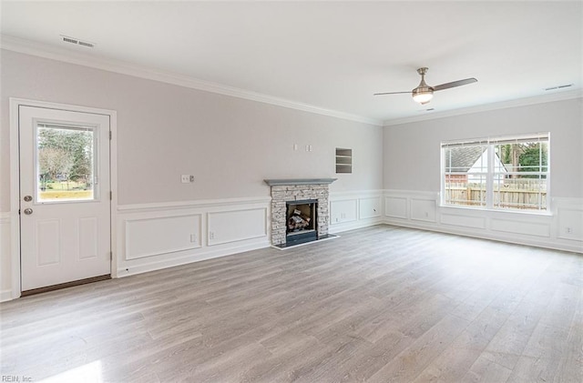 unfurnished living room with a wealth of natural light, ornamental molding, and a fireplace