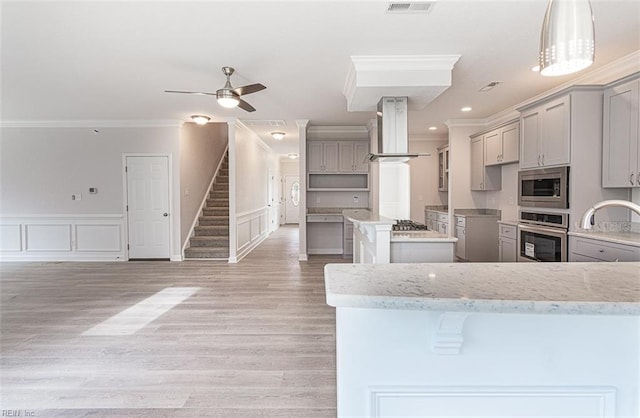 kitchen with island range hood, ceiling fan, stainless steel appliances, gray cabinetry, and crown molding