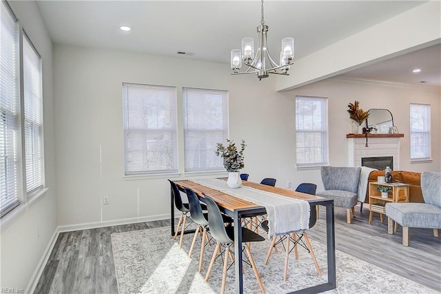 dining space with hardwood / wood-style flooring and a chandelier