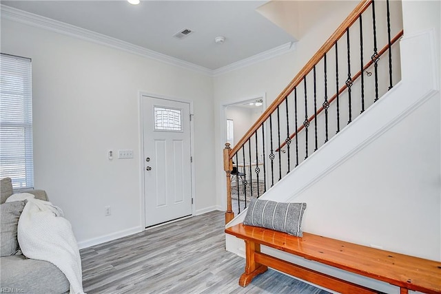 foyer entrance with hardwood / wood-style flooring and crown molding