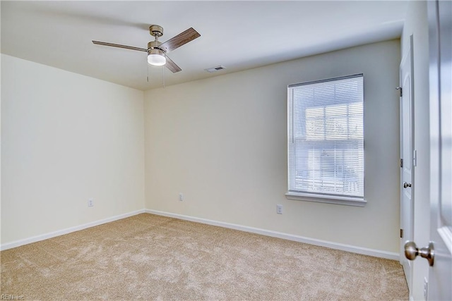 spare room with ceiling fan and light colored carpet