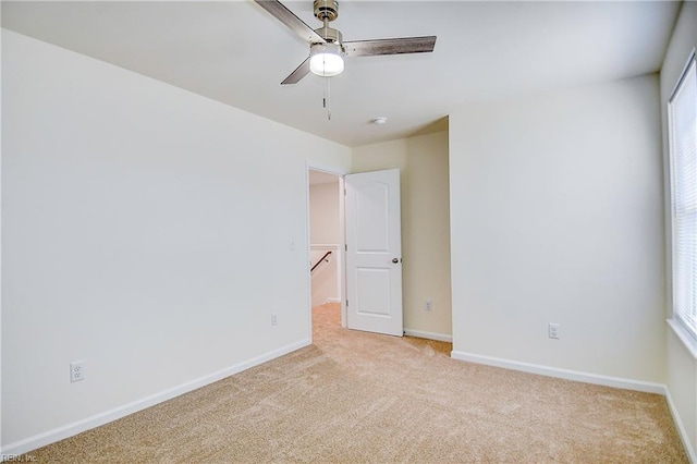 carpeted spare room with ceiling fan