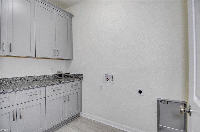 washroom featuring light tile patterned floors, washer hookup, hookup for an electric dryer, and cabinets