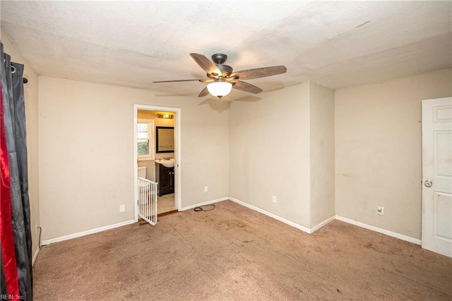 carpeted spare room featuring ceiling fan and a textured ceiling